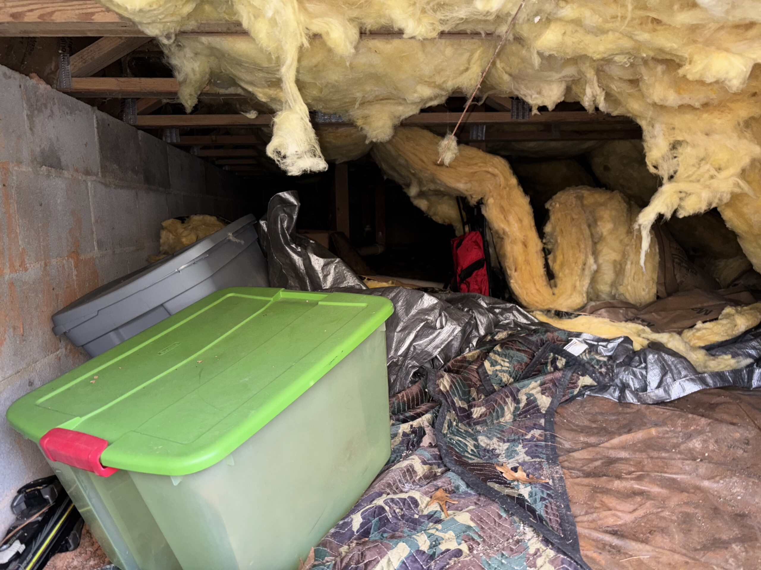 Before crawlspace encapsulation with exposed insulation and debris